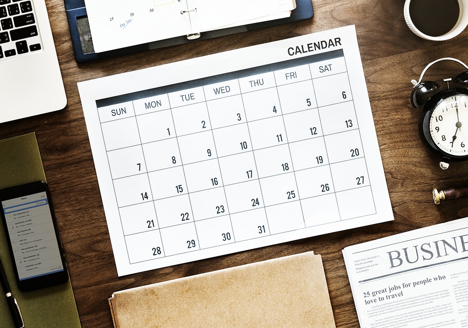 Kalender planen Arbeitstisch Holz Wecker Laptop Handy Zeitung Kaffee rustikal