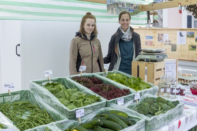 Gemüsemarkt Arosa zwei Frauen lächeln in Kamera Angebot Bohnen Salat Zucchetti